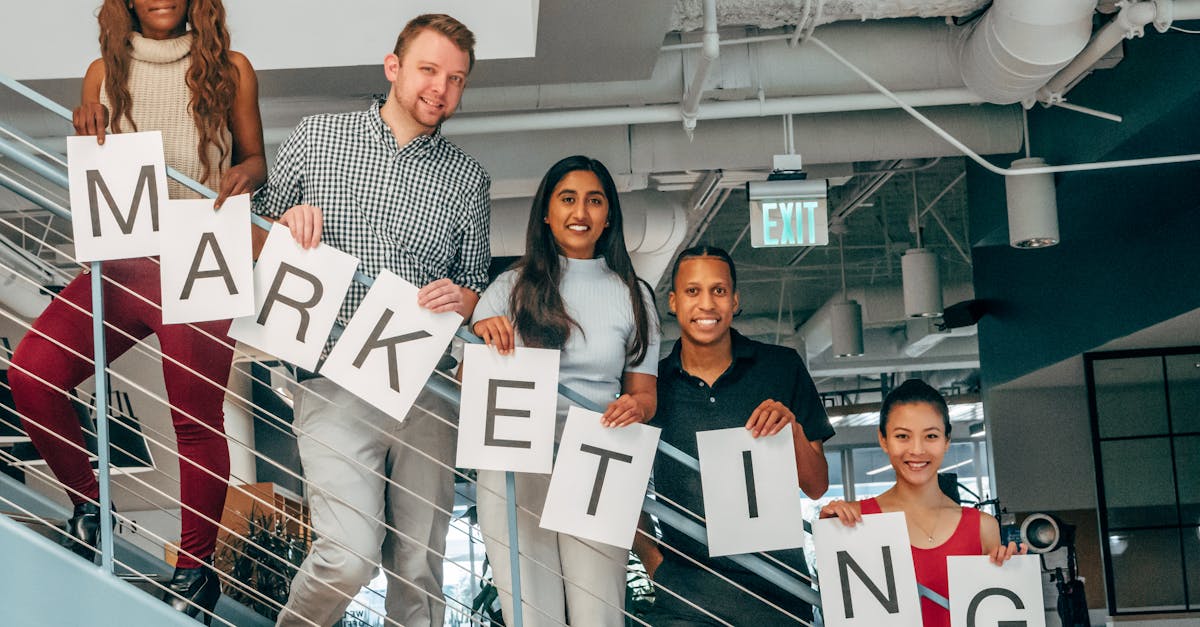A diverse group of professionals holding a marketing sign in a modern office setting.