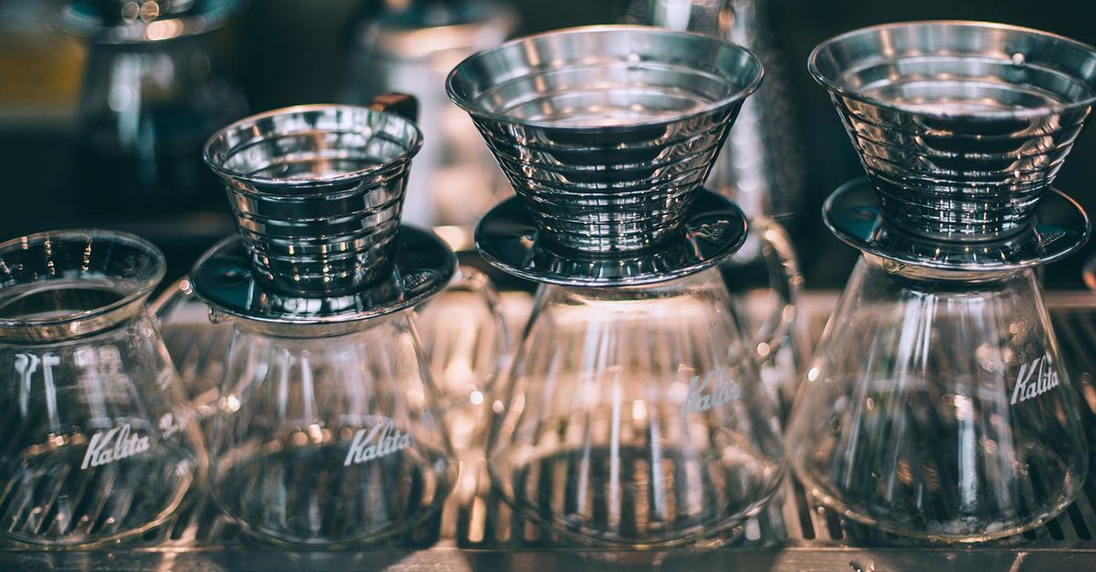 Set of similar crystal glass coffee pots with funnels for filters in coffee shop
