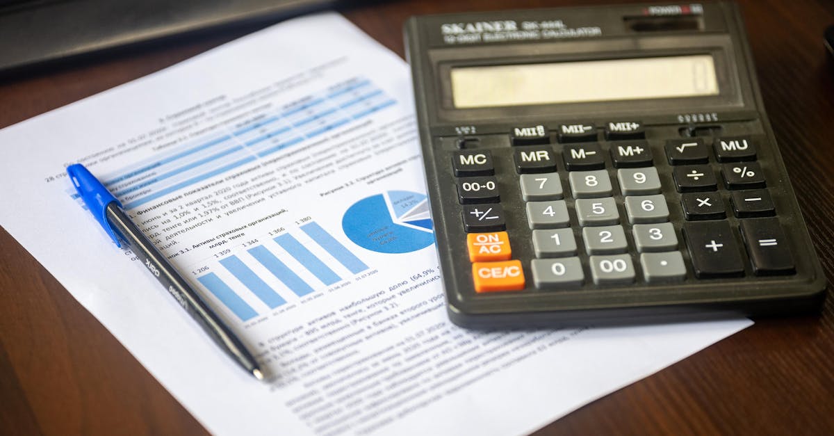 Close-up of a calculator, pen, and financial report on a wooden desk.