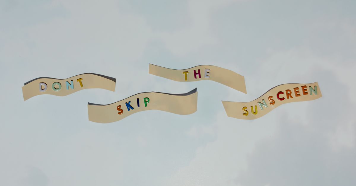 Colorful cutout letters forming a reminder to wear sunscreen against blue sky.