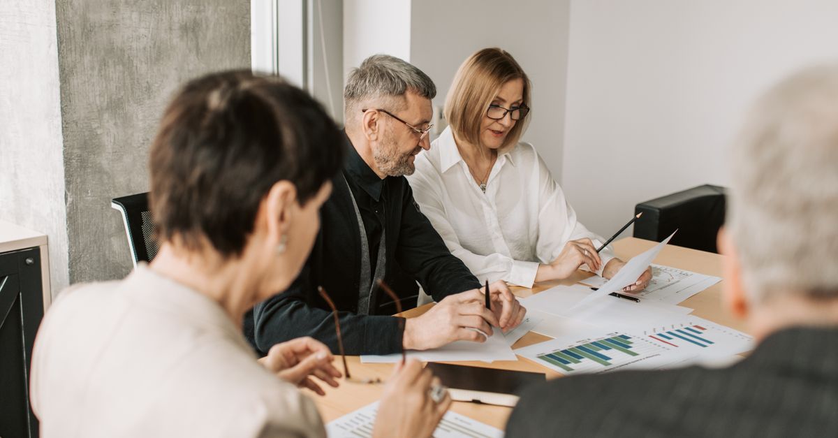Team of professionals in office analyzing financial documents for business strategy.
