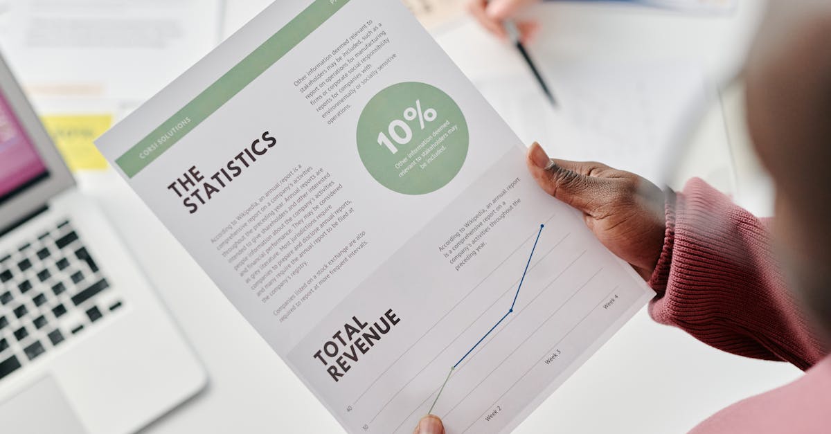 Hands holding a statistical report during a business meeting. Includes revenue graphs and analysis.