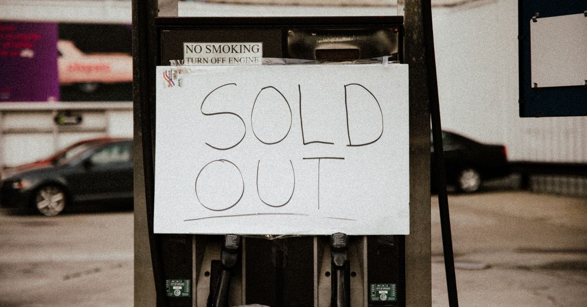 A gas pump at an urban station displaying a 'Sold Out' sign, illustrating fuel shortage.