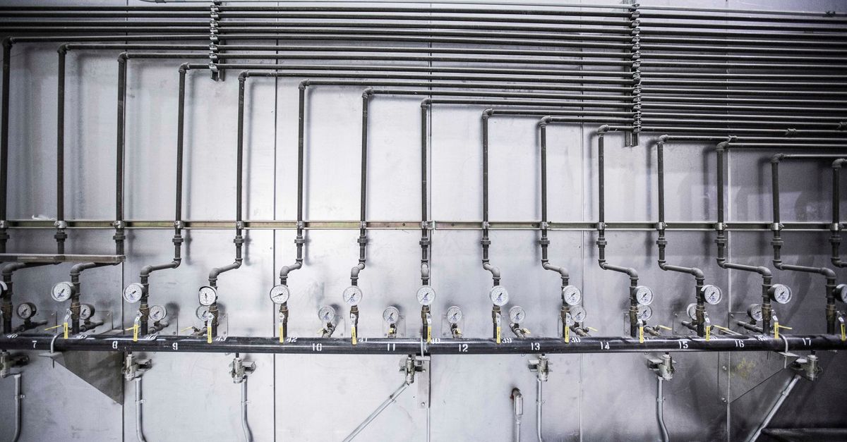 Detailed view of an industrial plumbing system featuring multiple pressure gauges and steel pipes.