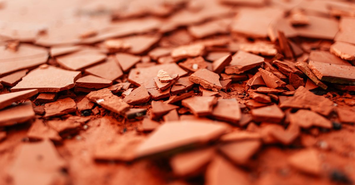 Detailed close-up of red broken ceramics highlighting texture and selective focus.