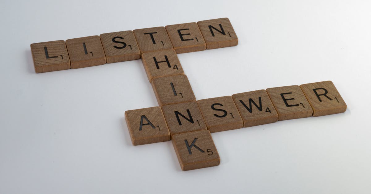 Wooden Scrabble tiles arranged on white surface forming words that inspire thought and communication.