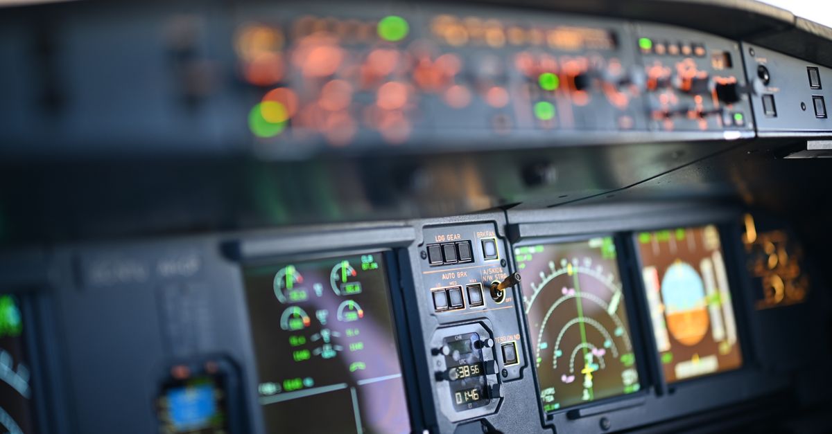 Close-up view of airplane cockpit instrumentation with modern digital displays.
