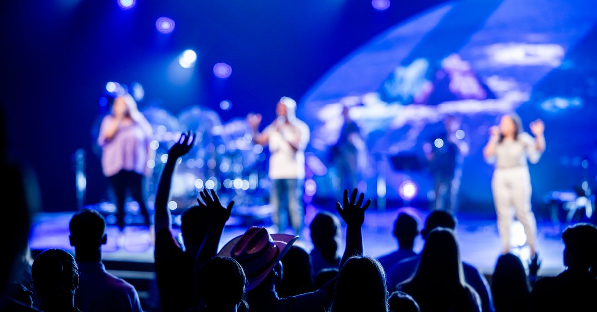 A lively concert scene with a vibrant audience engaging with live music on stage.