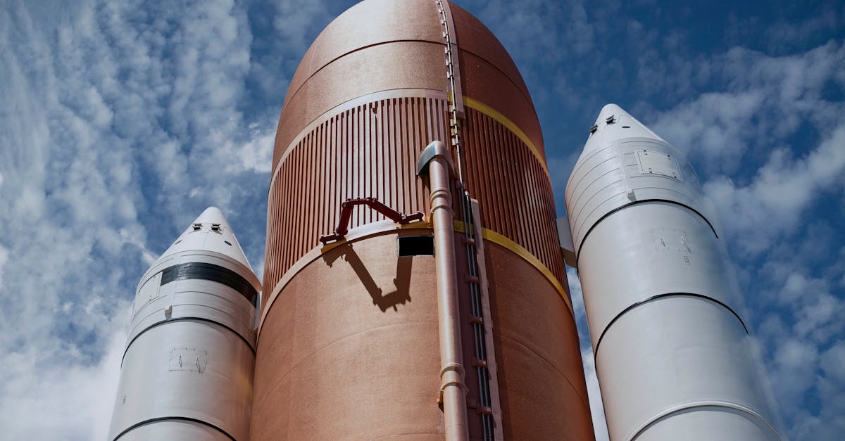 Dramatic view of rocket boosters against a bright blue sky, showcasing aerospace technology.