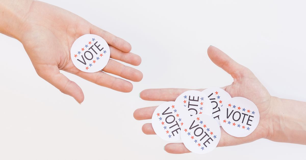 Close-up of hands holding election vote stickers, symbolizing participation.