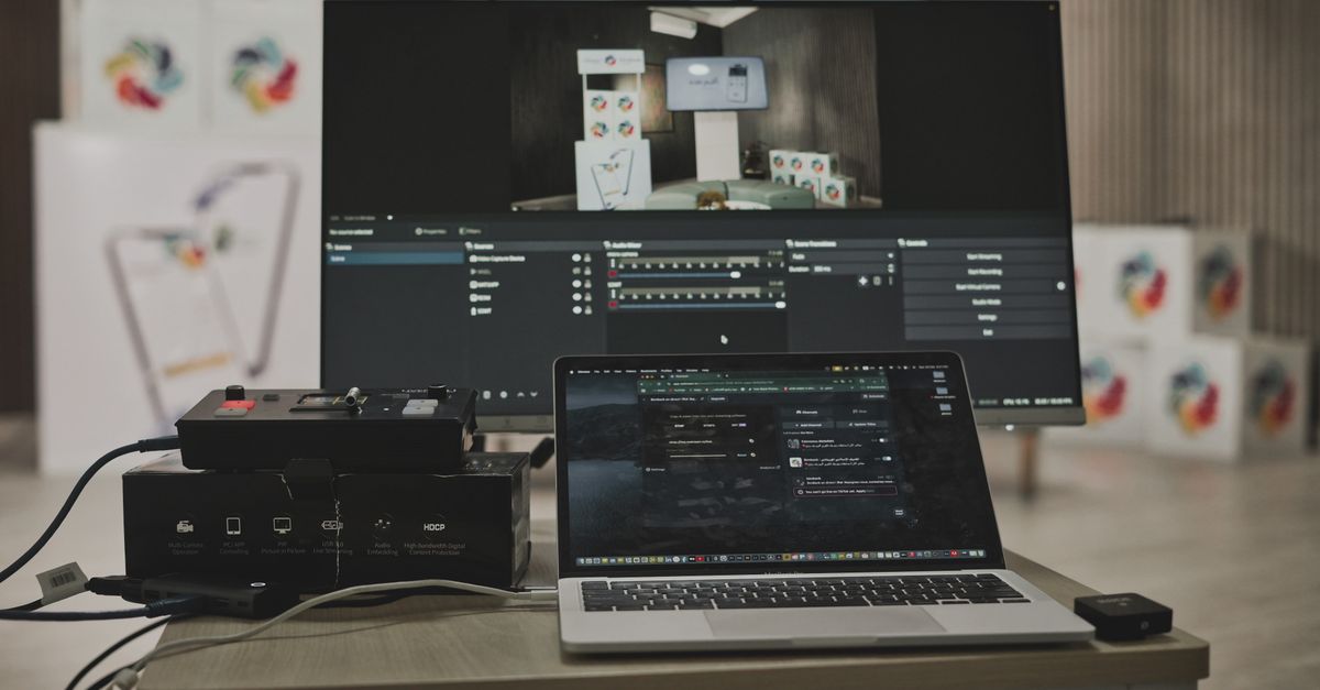 Multimedia setup featuring a laptop and a large monitor in a tech-savvy workspace.