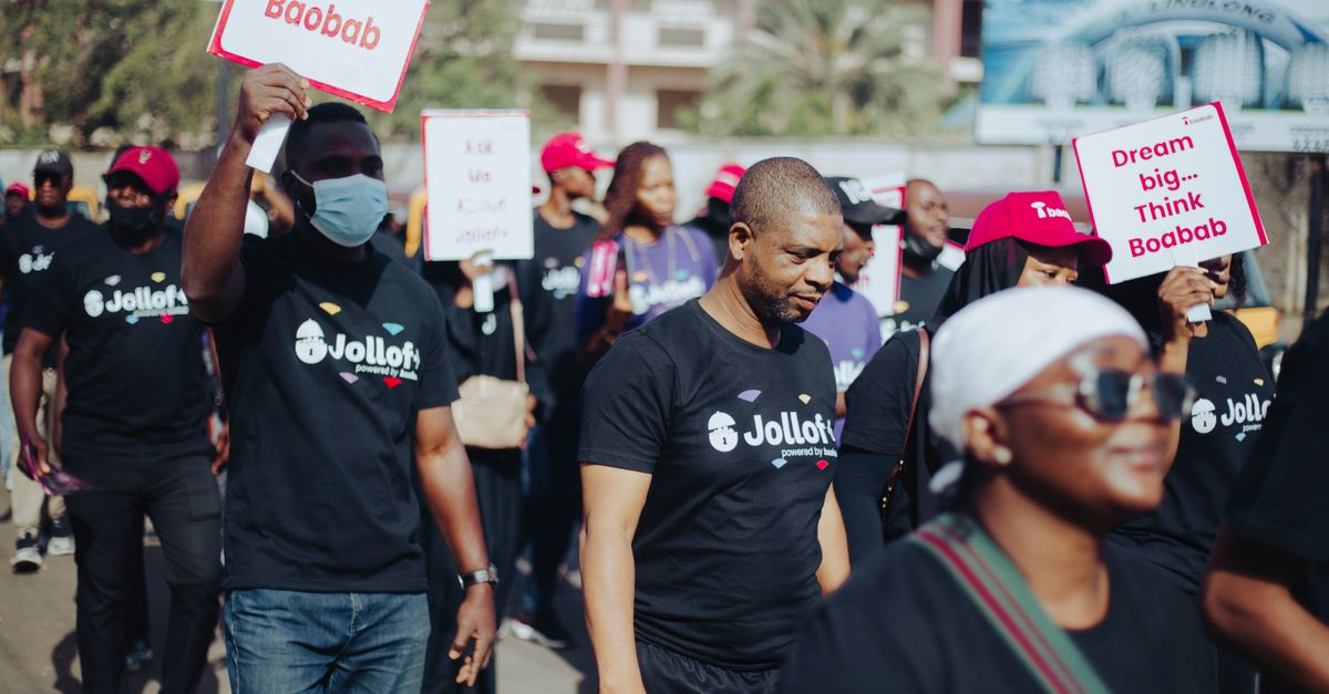 A group participating in a community walk for Baobab awareness, carrying signs.