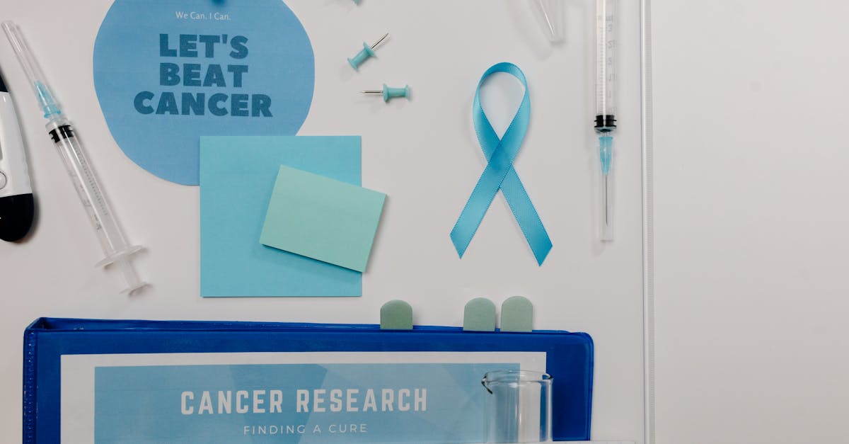 Flat lay showing cancer awareness items with blue ribbon and research tools.