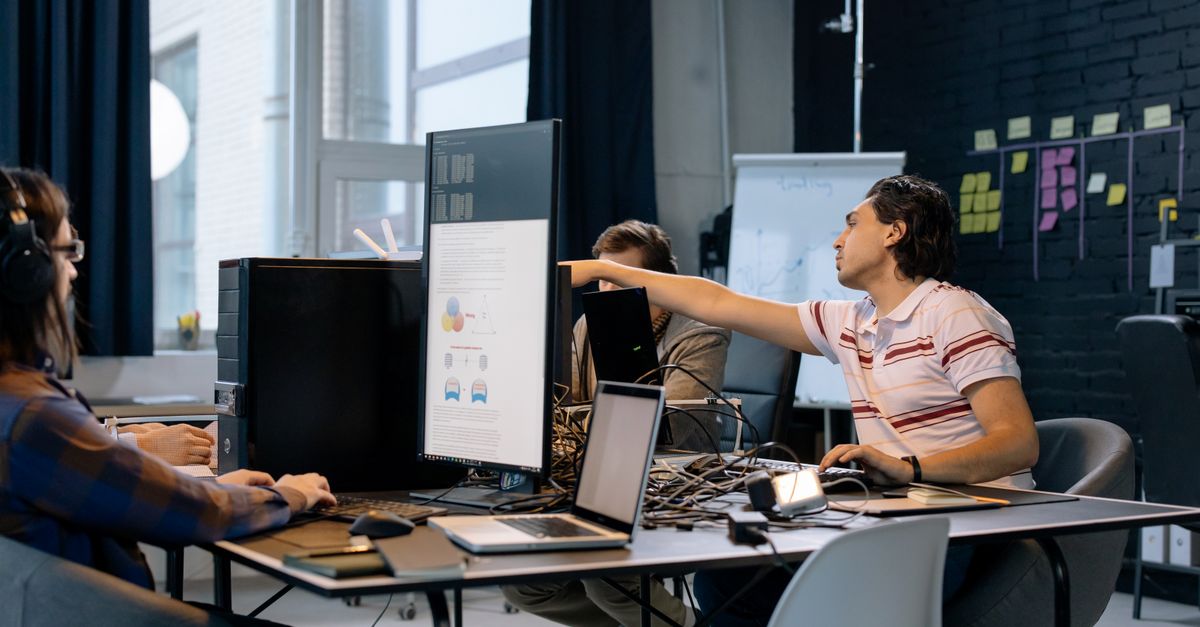 Group of young professionals working on software development in a creative indoor workspace.