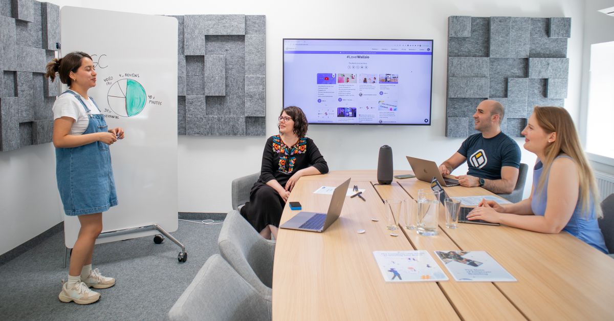 Team collaborating during a meeting with presentation and discussion in a modern office.