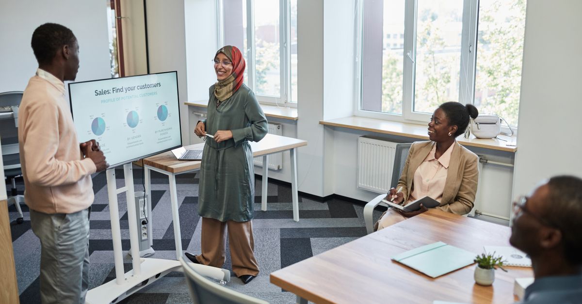 Multicultural team having a business presentation in a modern office setting.