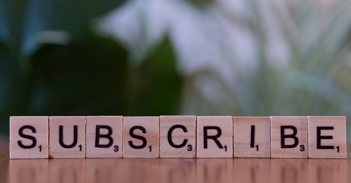 Close-up of the word 'SUBSCRIBE' spelled with wooden letter tiles on a table.