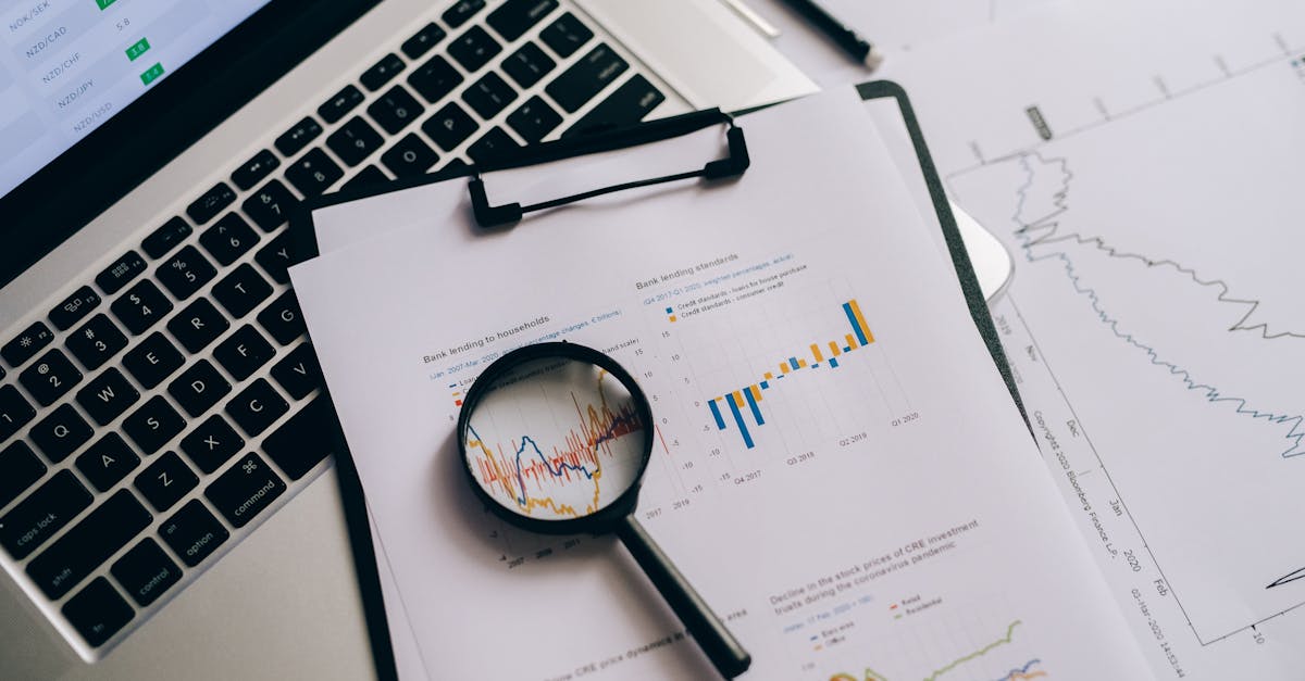 Overhead view of financial charts, laptop, and magnifying glass, ideal for business analysis themes.