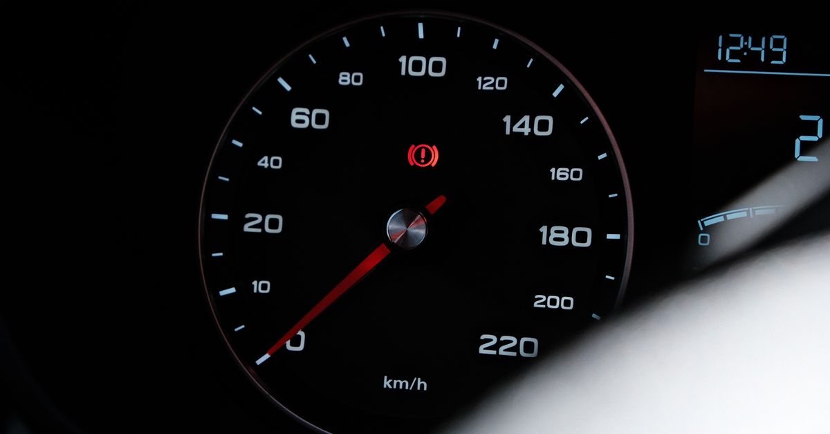 Detailed view of a car speedometer showing speed in km/h with a warning light
