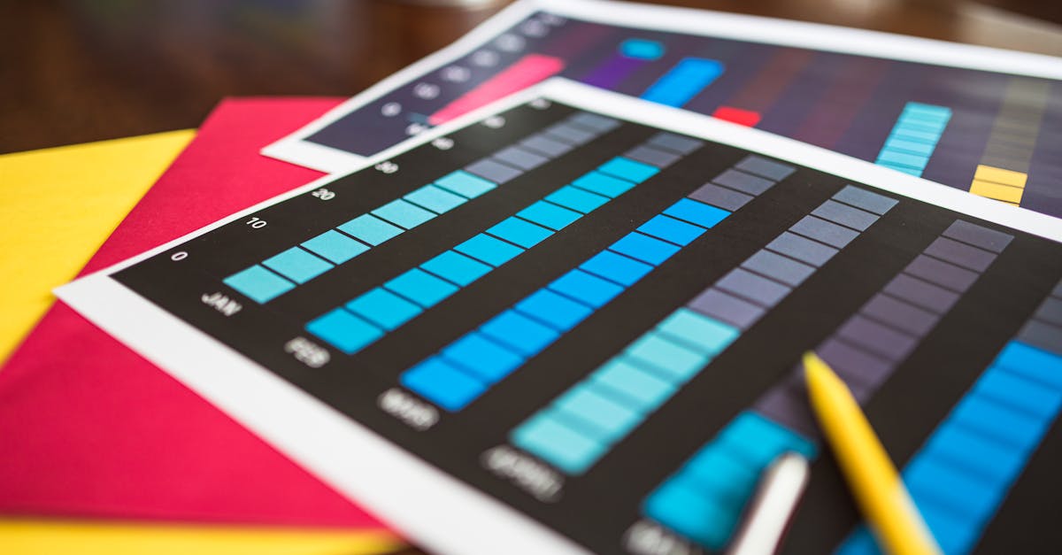 Close-up of colorful financial charts and a pencil on a wooden desk.