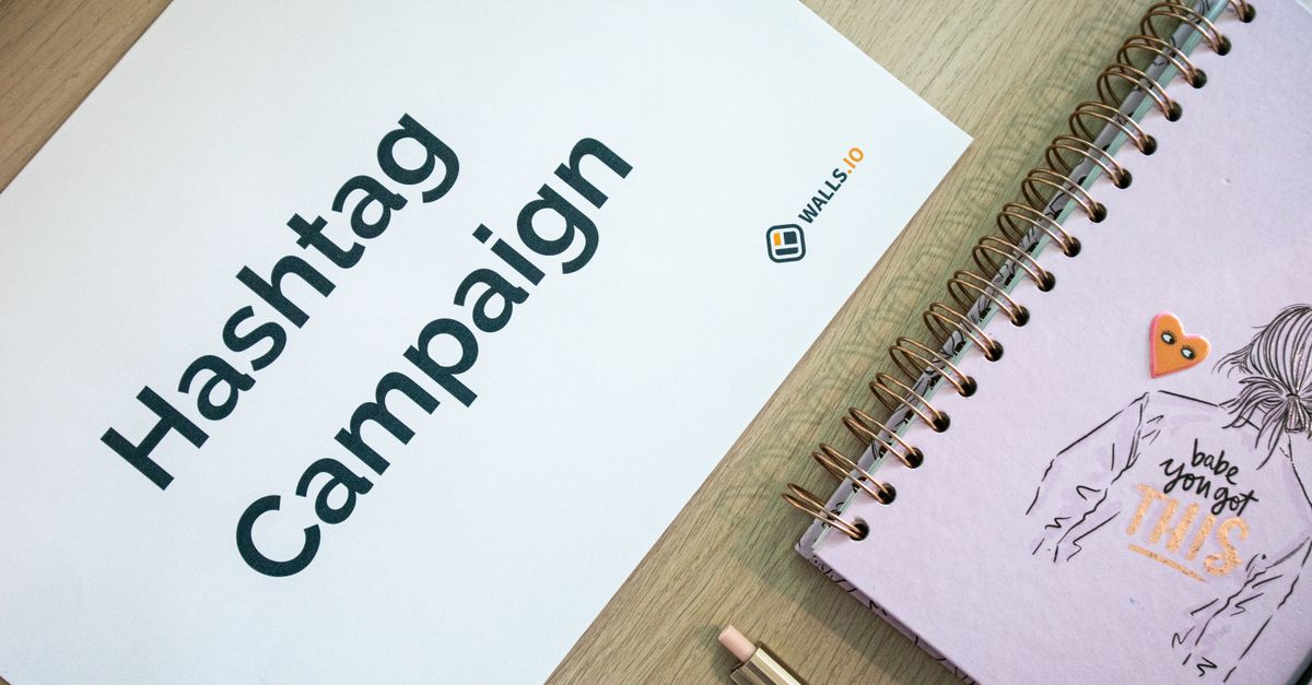 Creative desk setup featuring a hashtag campaign paper and a motivational notebook, ideal for marketing and planning themes.