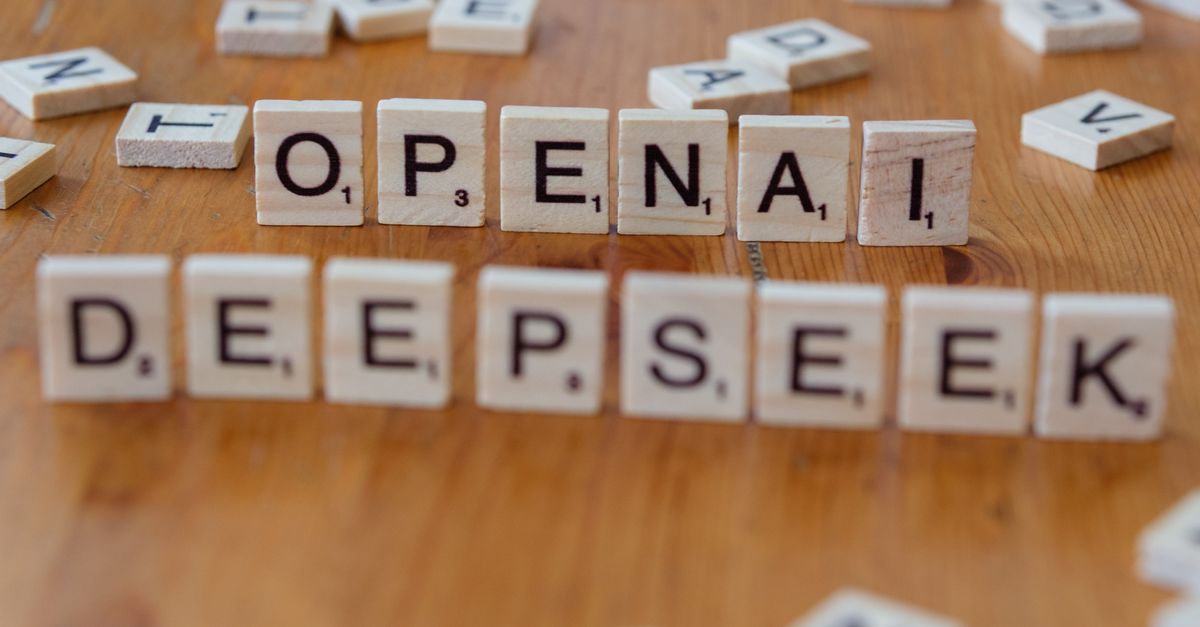 Close-up of wooden Scrabble tiles spelling OpenAI and DeepSeek on wooden table.
