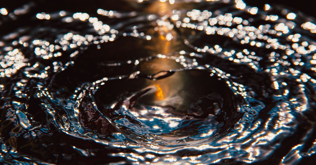Closeup of rings on transparent splashing clear water illuminated with beam of sunlight