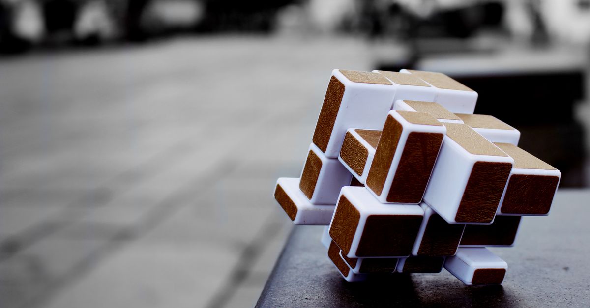 Artistic cube puzzle placed on a surface in an urban setting, capturing depth and focus.