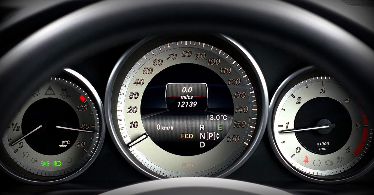 Close-up image of a car dashboard highlighting speedometer, odometer, and temperature gauge.