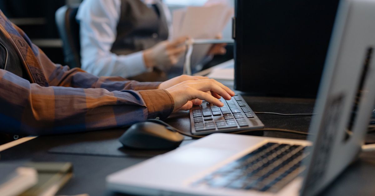 Close-up of office workers engaged in a tech project at a modern workplace.