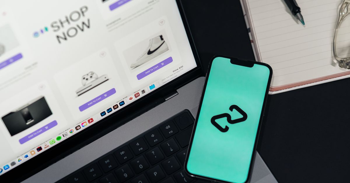 A smartphone and laptop displaying online shopping platforms, suggesting digital retail.