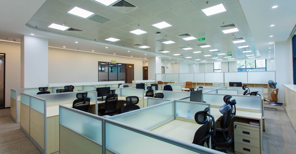 Spacious open-plan office with cubicles and modern furnishings, ideal for collaborative work environments.