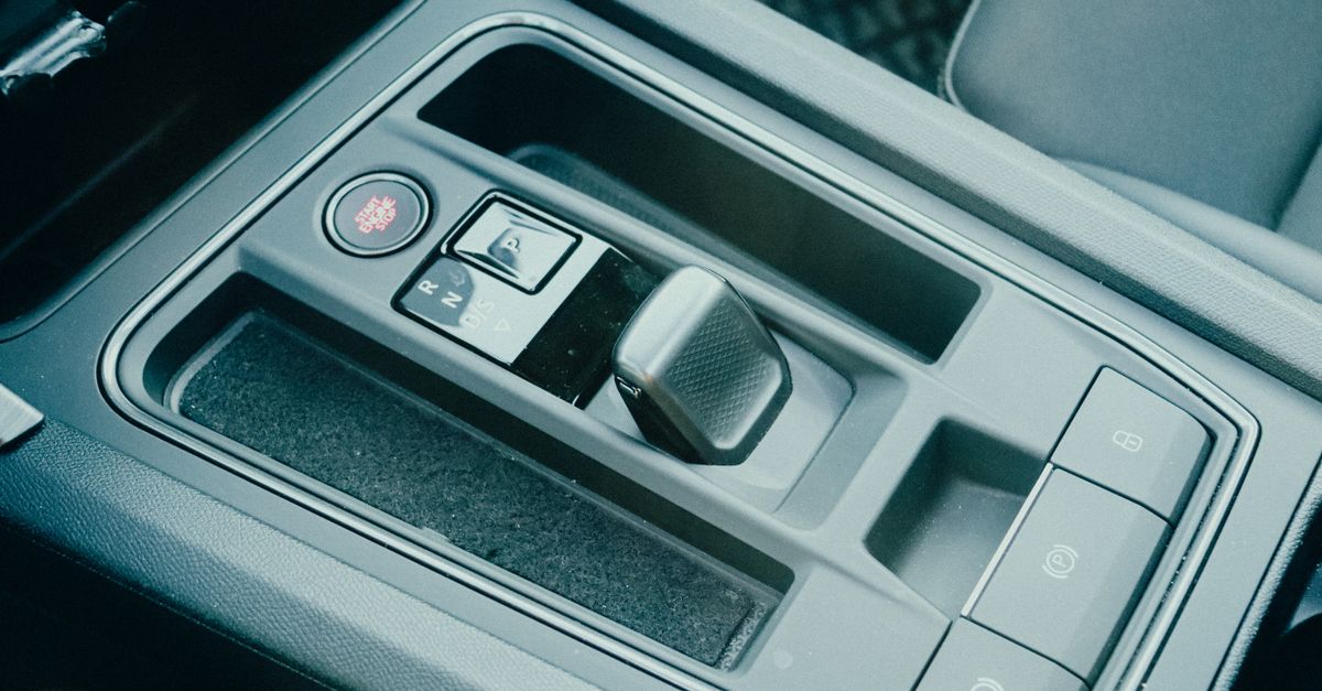 Close-up of a modern car's gear shift knob in an interior setting, showcasing advanced automotive technology.