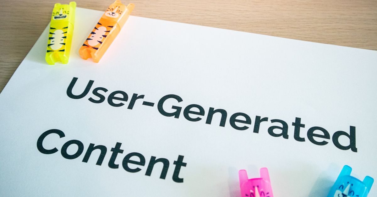 Bright highlighters on a 'User-Generated Content' note against a wooden desk.